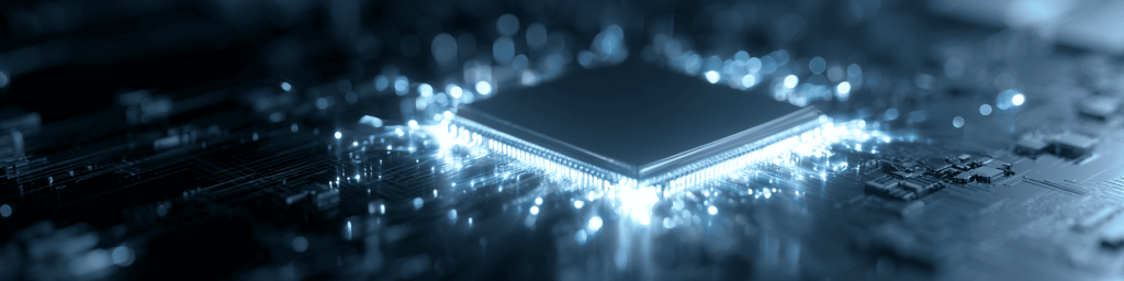 Panoramic dark teal tech banner featuring a square semiconductor CPU with glowing lit pin contacts, set atop intricate circuit traces surrounded by soft blurred blue bokeh light particles.